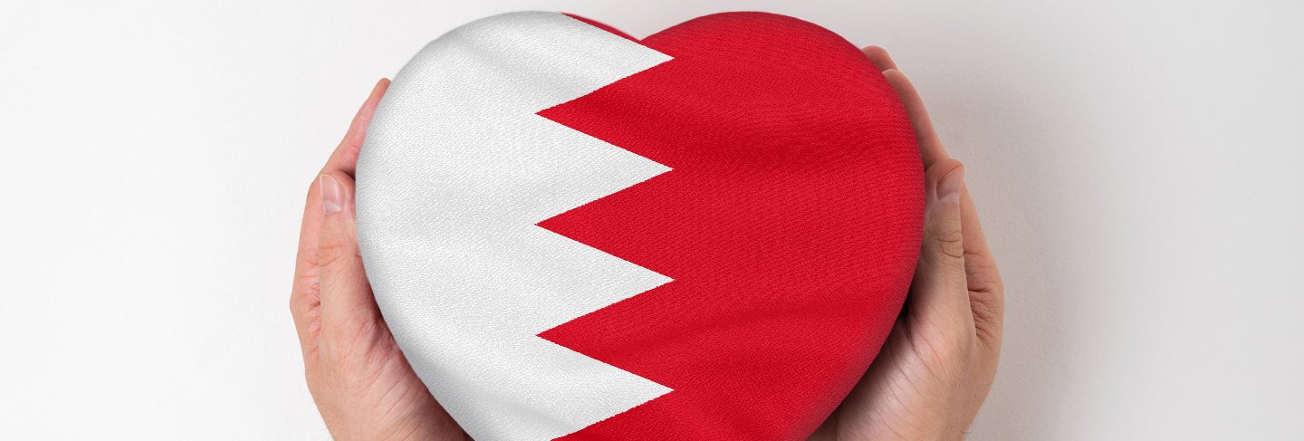 Flag of bahrain on a heart shaped box in a male hands.