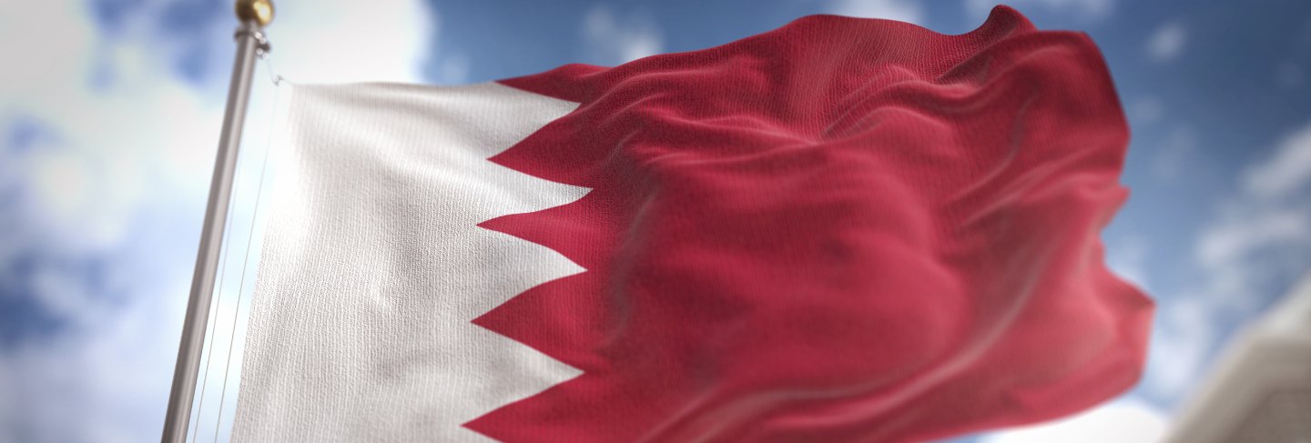 Bahrain flag 3d rendering on blue sky building background 