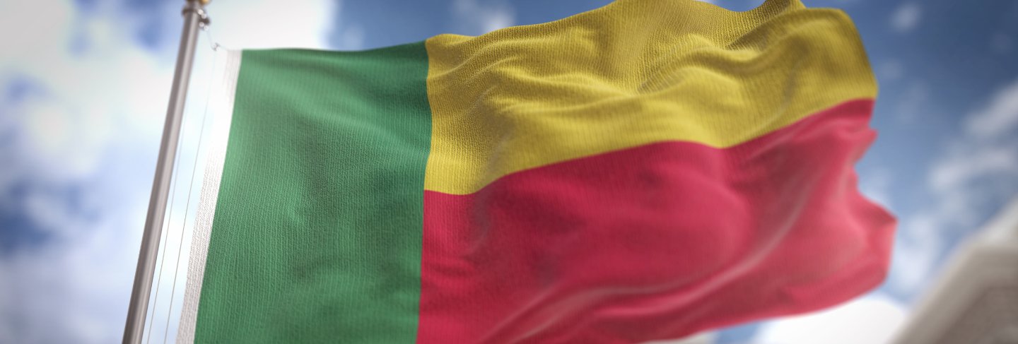 Benin flag 3d rendering on blue sky building