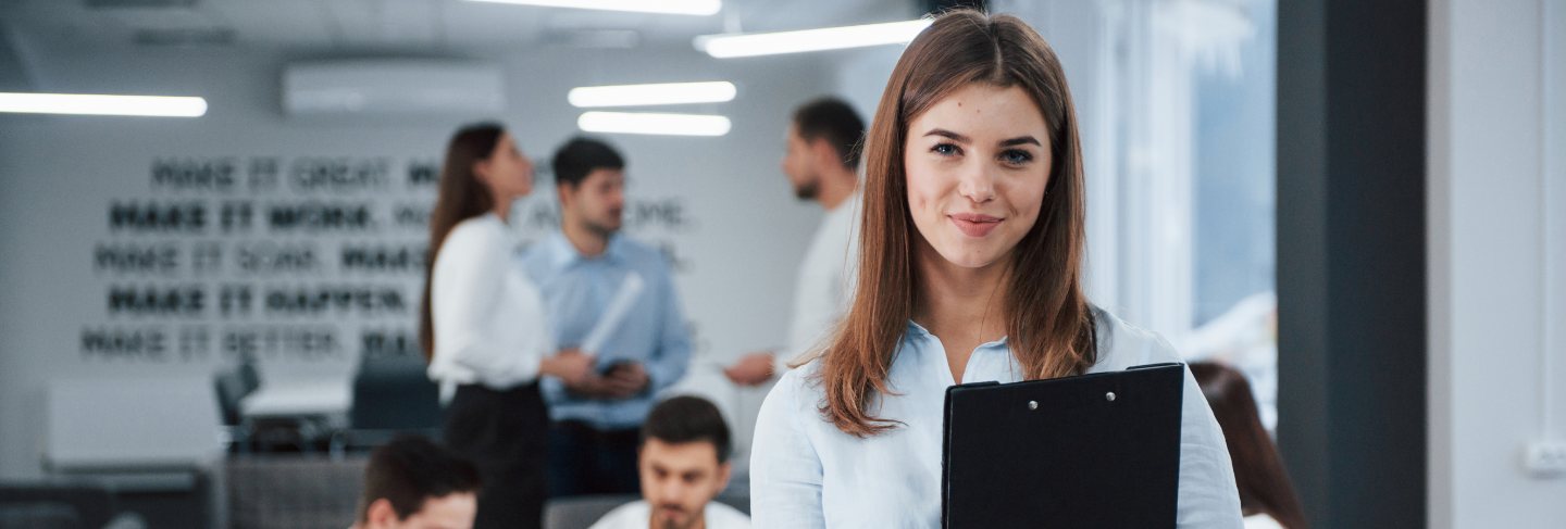 Conception of success. portrait of young girl stands in the office with employees