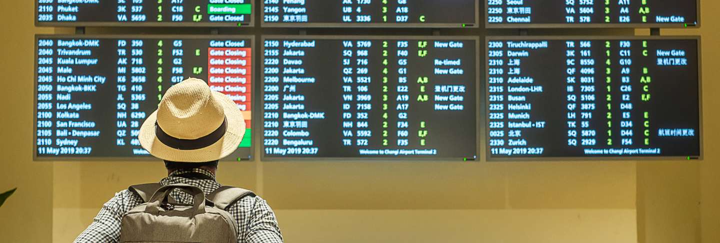 Young man traveler with hat checking flight time
