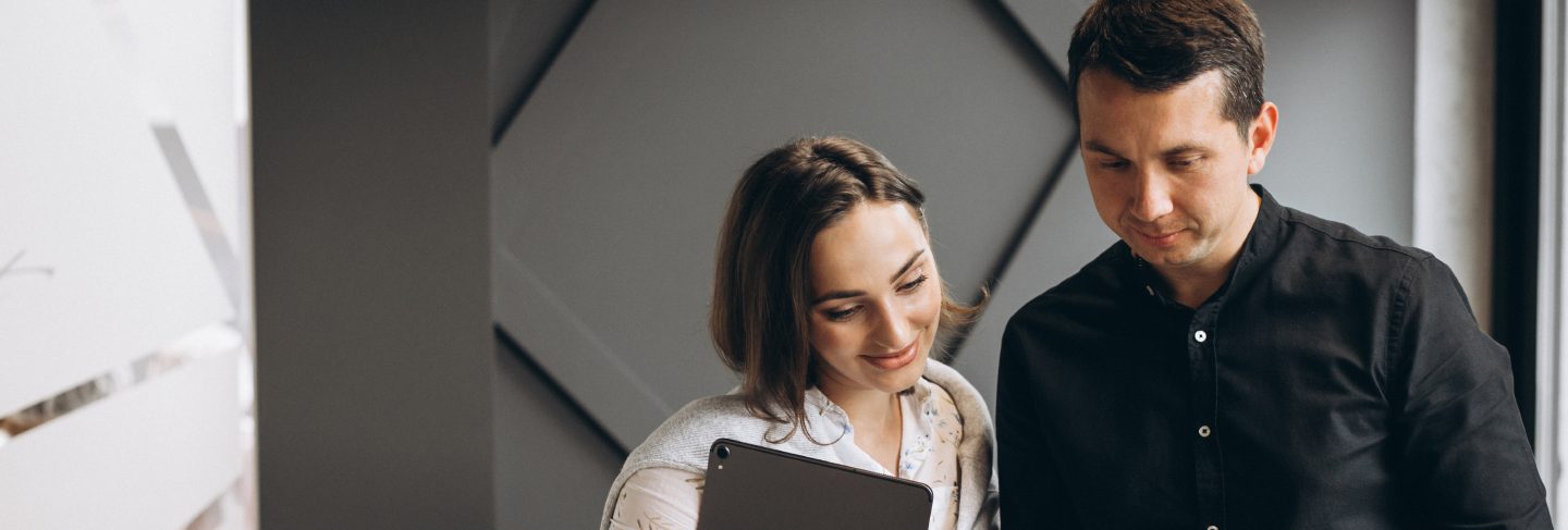 Business woman and bussiness man colleagues working on laptop