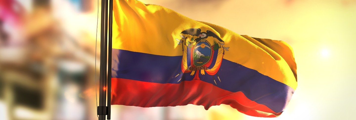 Ecuador flag against city blurred background at sunrise backlight