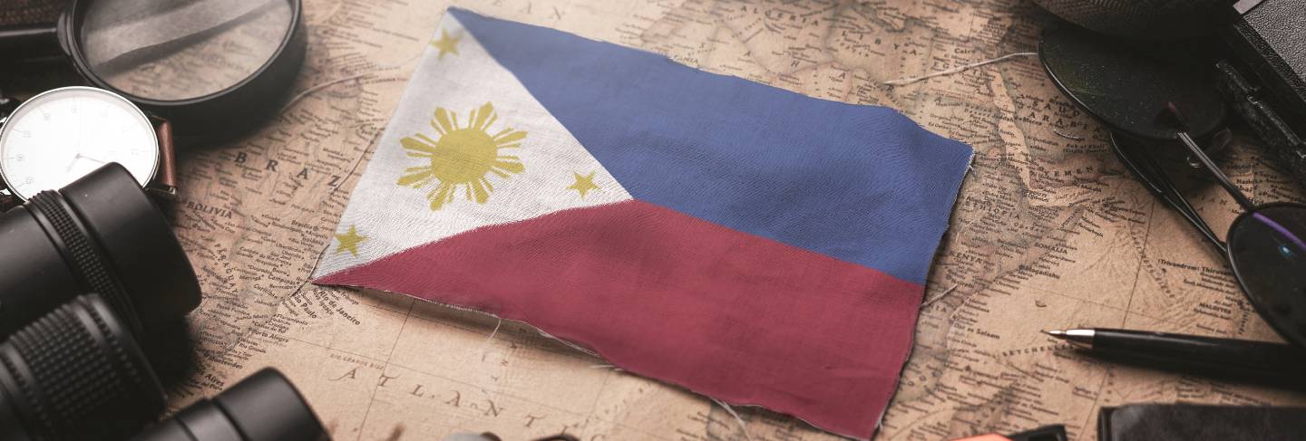Philippines flag between traveler's accessories on old vintage map. tourist destination concept