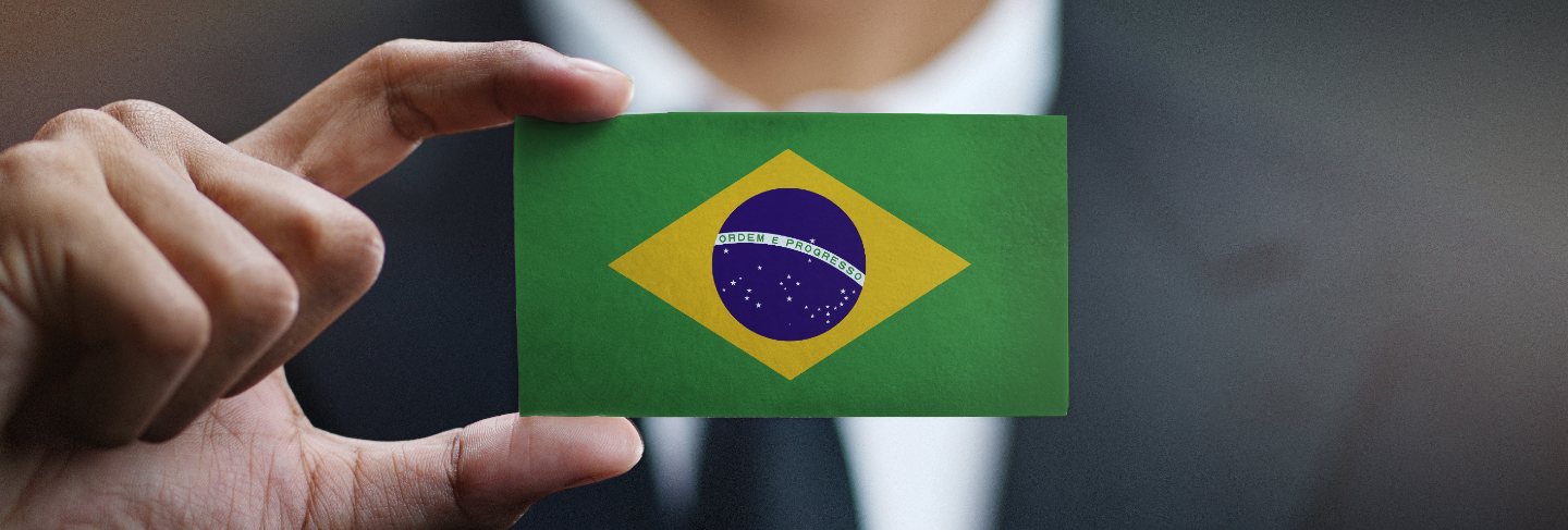 Businessman holding card of brazil flag