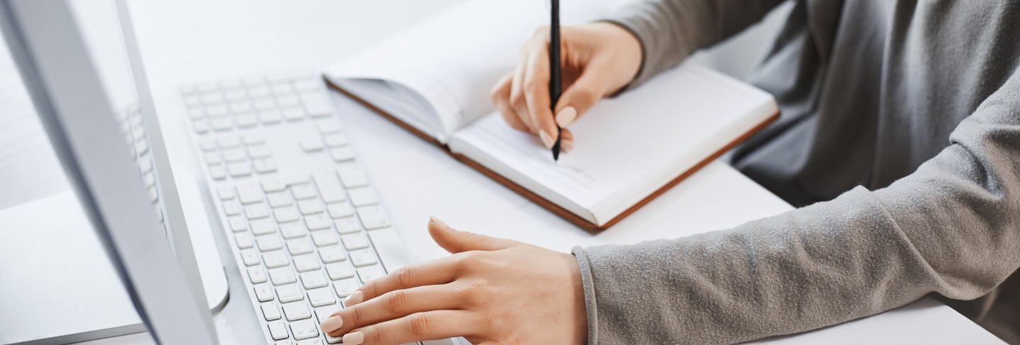 I can handle multi tasks. cropped shot successful girl typing on keyboard and making notes while looking at computer screen and studying new business graphic