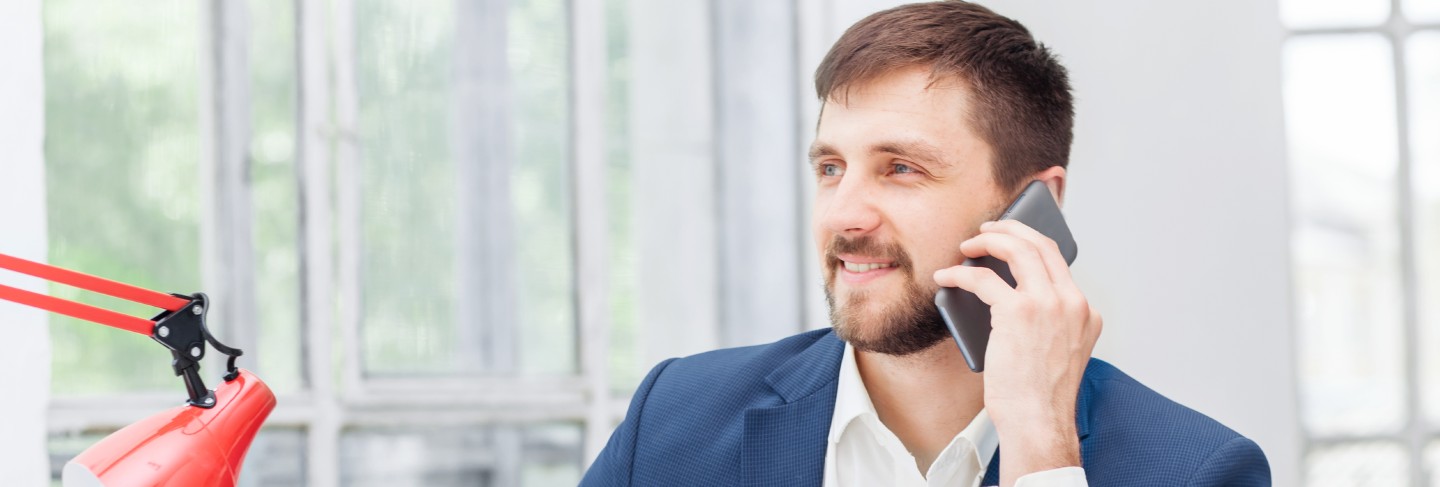 Portrait of businessman talking on phone in office