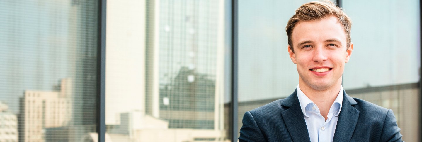 Smiling businessman with crossed arms looking at camera