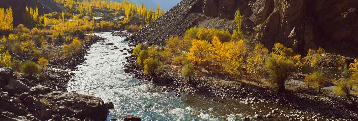 Winding river flowing along valley in hindu kush mountain range. autumn season in pakistan Premium Photo