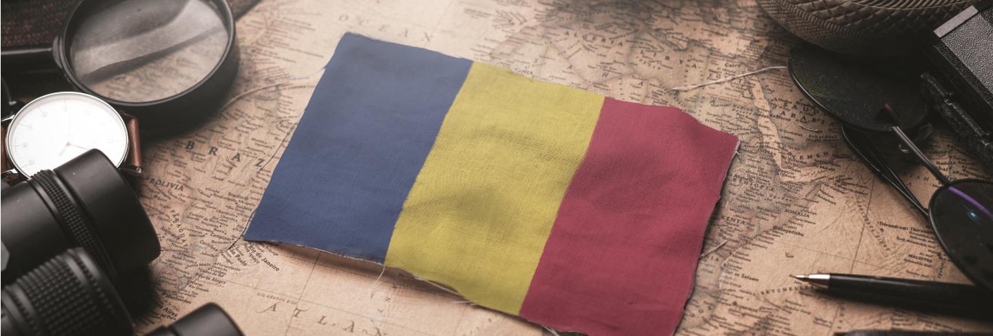 Romania flag between traveler's accessories on old vintage map. tourist destination concept.