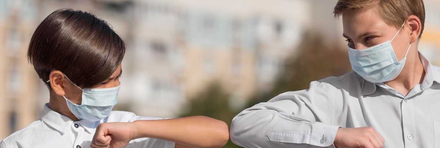 Front view of kids greeting with elbow bump