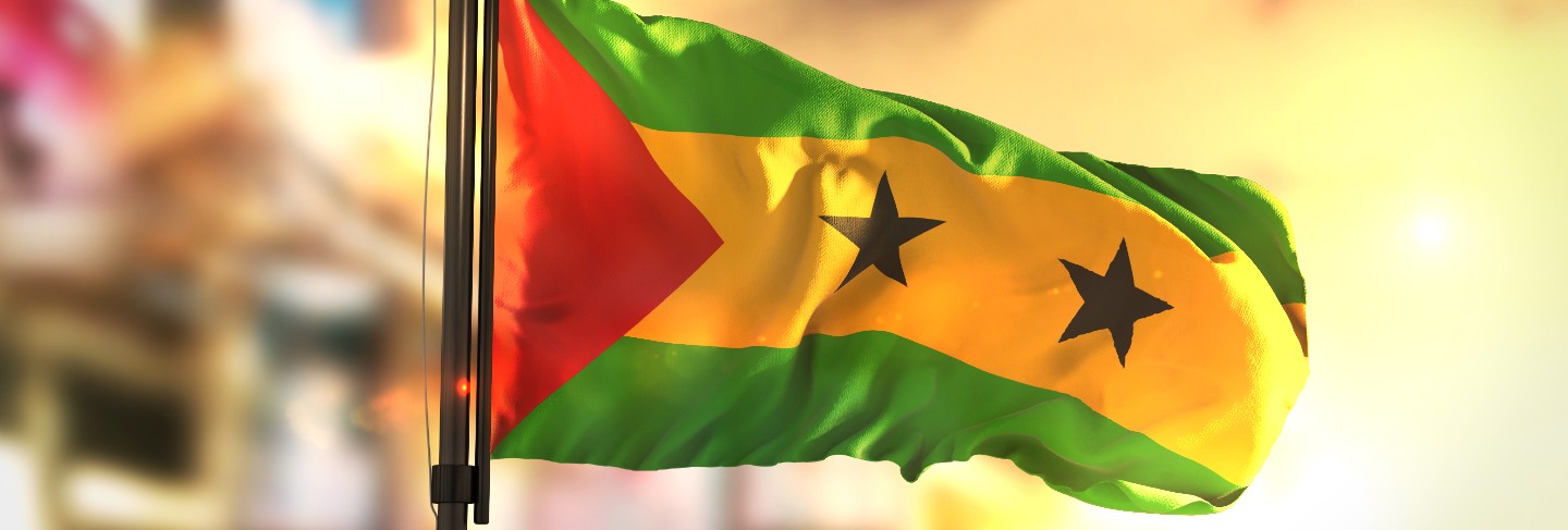 São tomé and príncipe flag against city blurred background at sunrise backlight