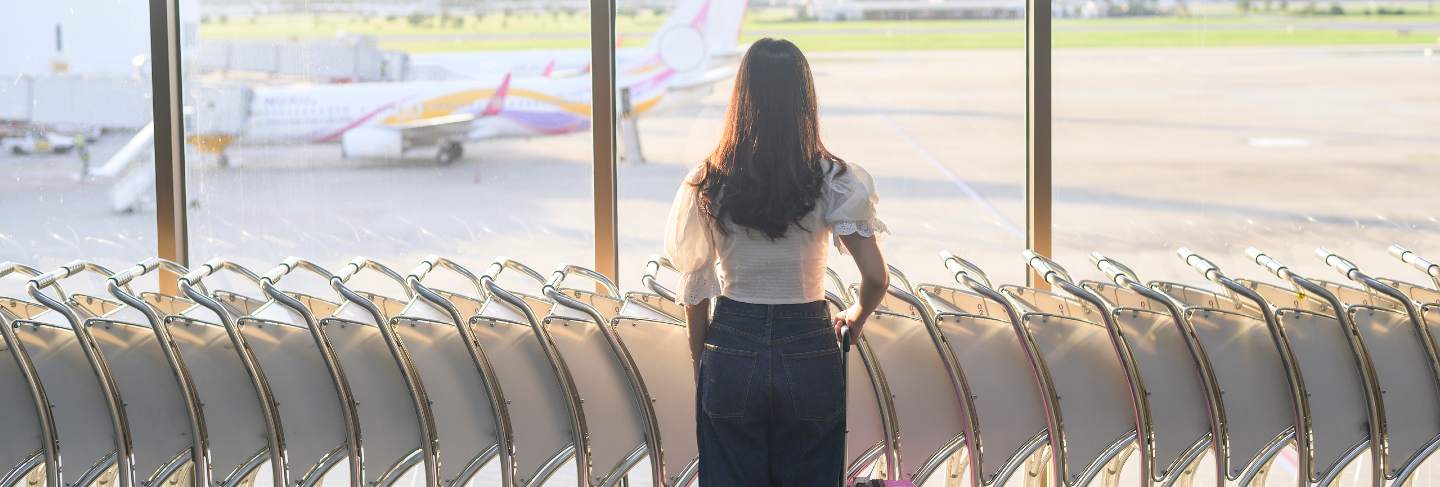 A traveller woman is wearing protective mask in international airport, travel under covid-19 pandemic, safety travels, social distancing protocol