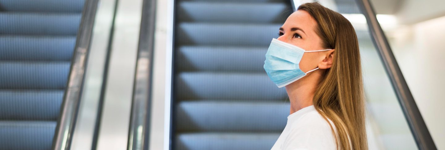 Woman with face mask on the escalator