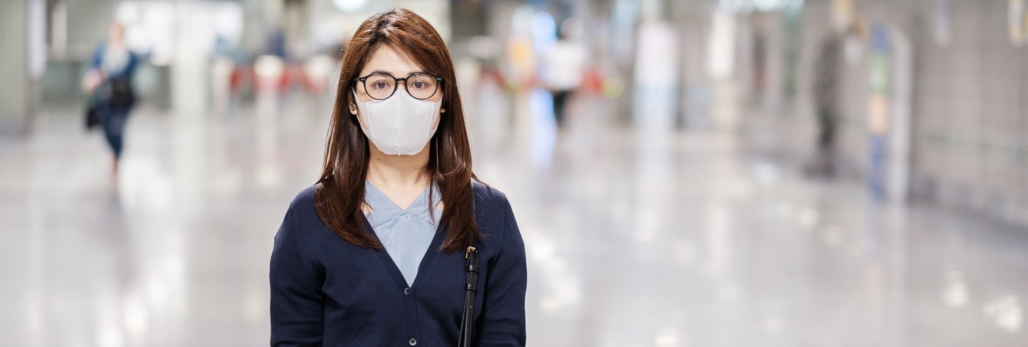 Young asian woman wearing protection mask against novel coronavirus or corona virus disease (covid-19) at airport