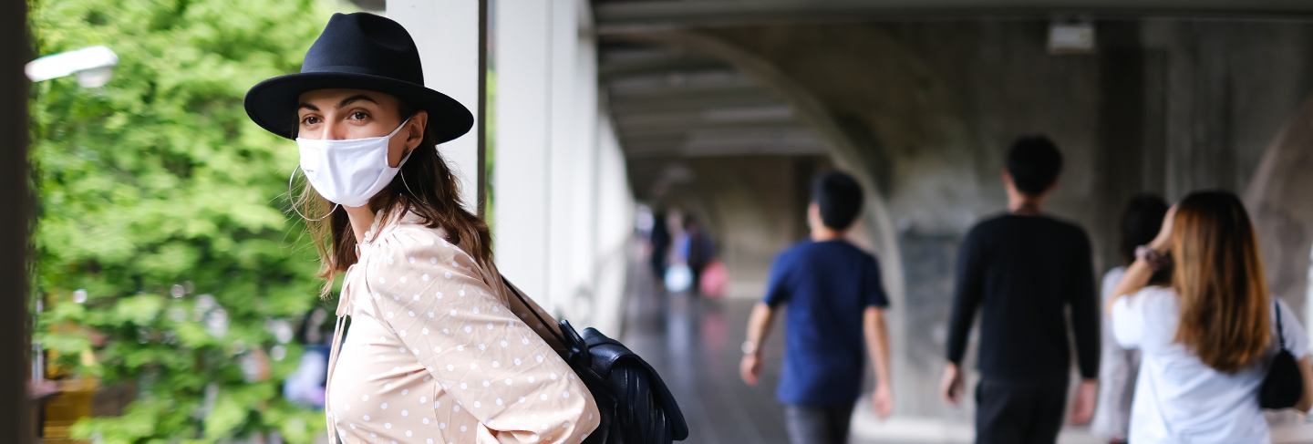 Caucasian woman walking on subway crossing in medical face mask while pandemia in bangkok city.