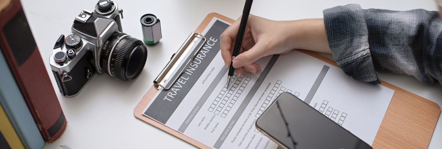 Female filling travel insurance form while looking her travel plan on smartphone