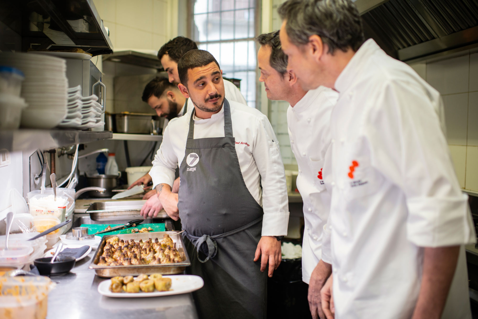 Paul junto a los barceloneses en la cocina. Juntos han preparado 260 tapas de alcachofa. Paul junto a los barceloneses en la cocina. Juntos han preparado 260 tapas de alcachofa.