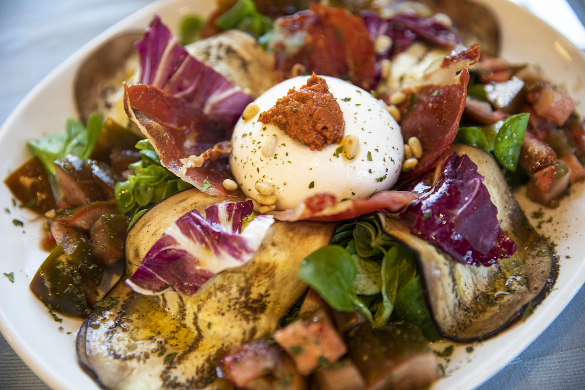 Ensalada de burrata con berenjena, canónigos y piñones con salsa de tomate seco y anchoa. Ensalada de burrata con berenjena, canónigos y piñones con salsa de tomate seco y anchoa.