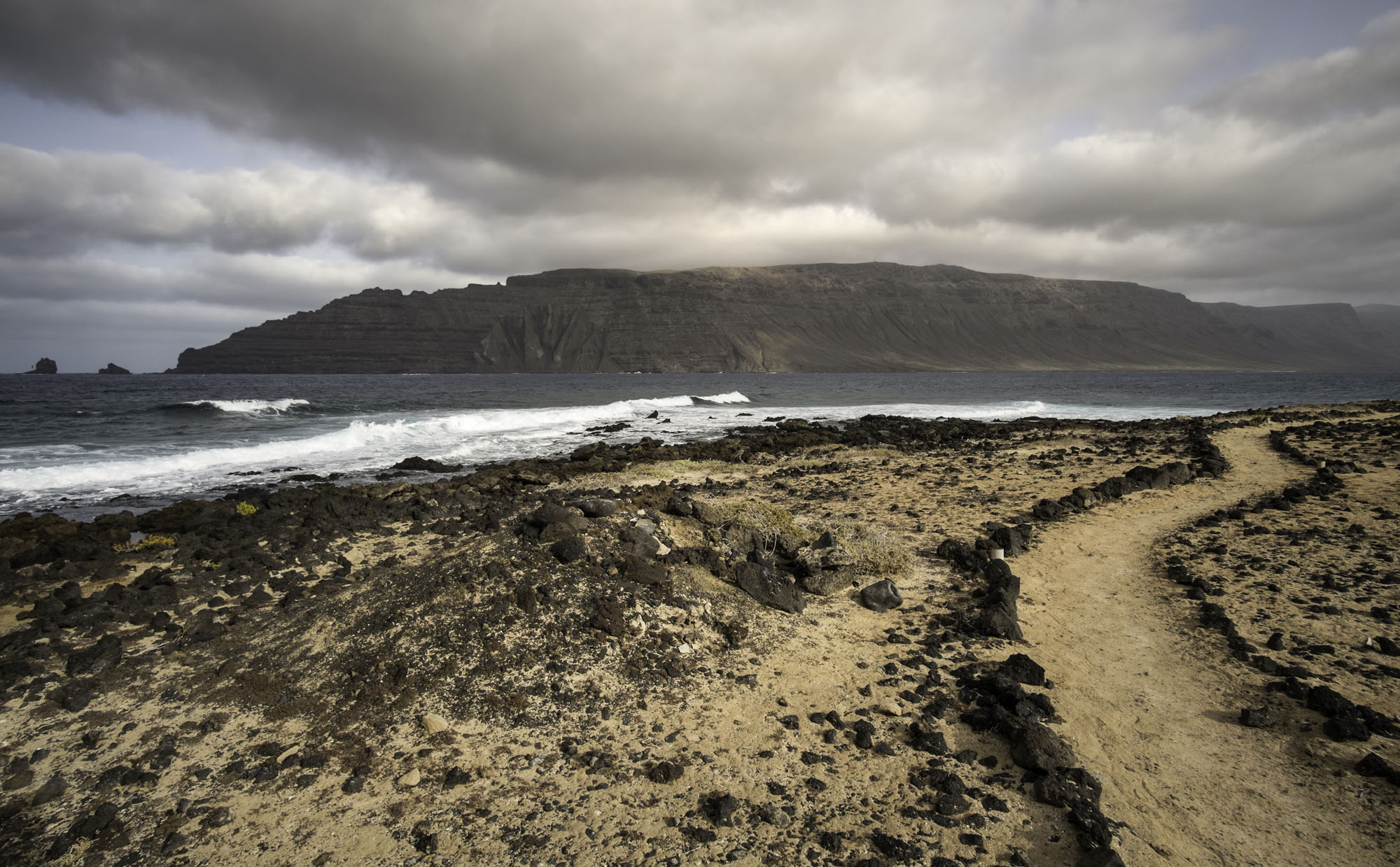La isla de Lanzarote se divisa a lo lejos. La isla de Lanzarote se divisa a lo lejos.
