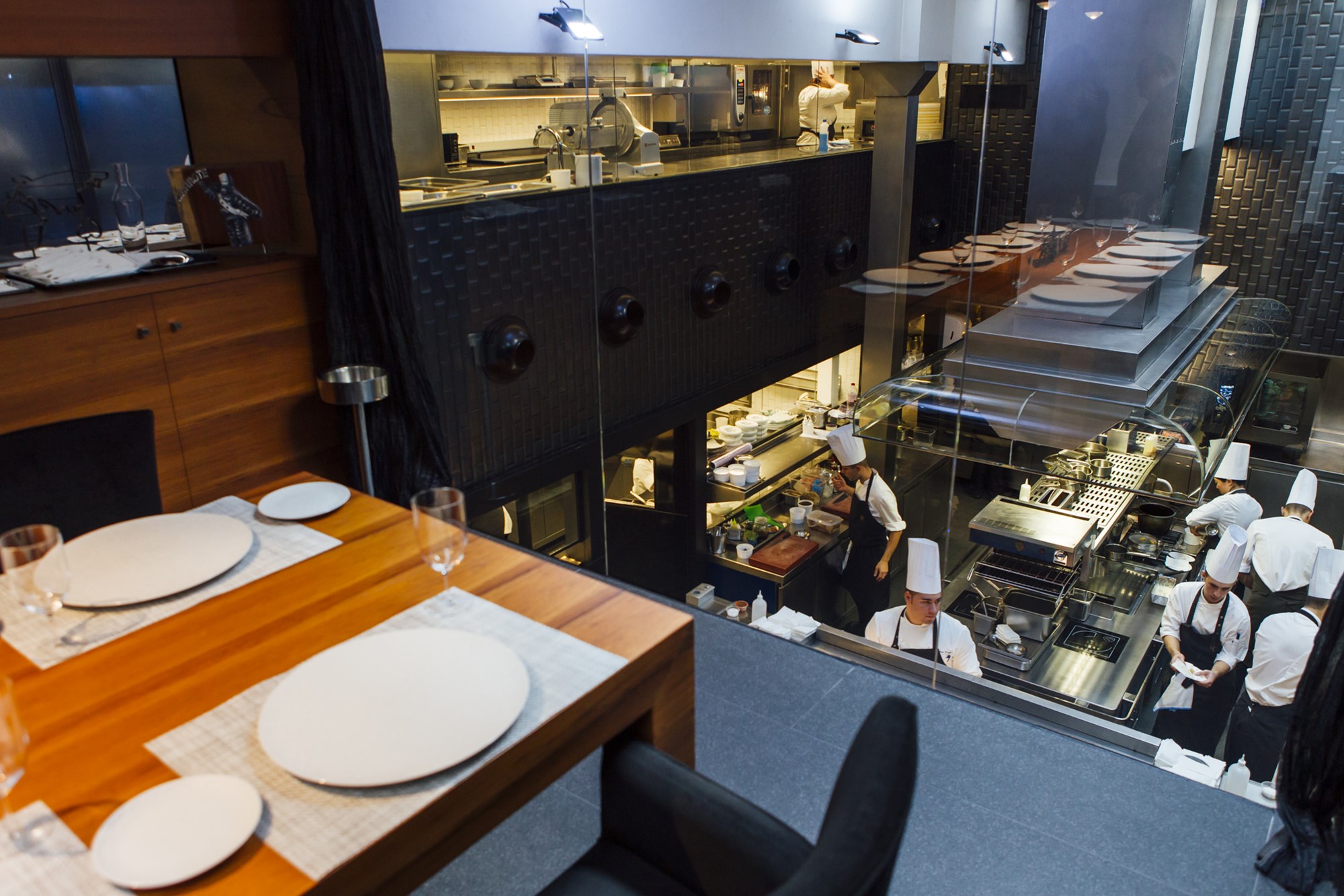 La mesa de la cocina, con una visión panorámica de todo lo que sucede durante el servicio gracias a la gran ventana indiscreta. La mesa de la cocina, con una visión panorámica de todo lo que sucede durante el servicio gracias a la gran ventana indiscreta.