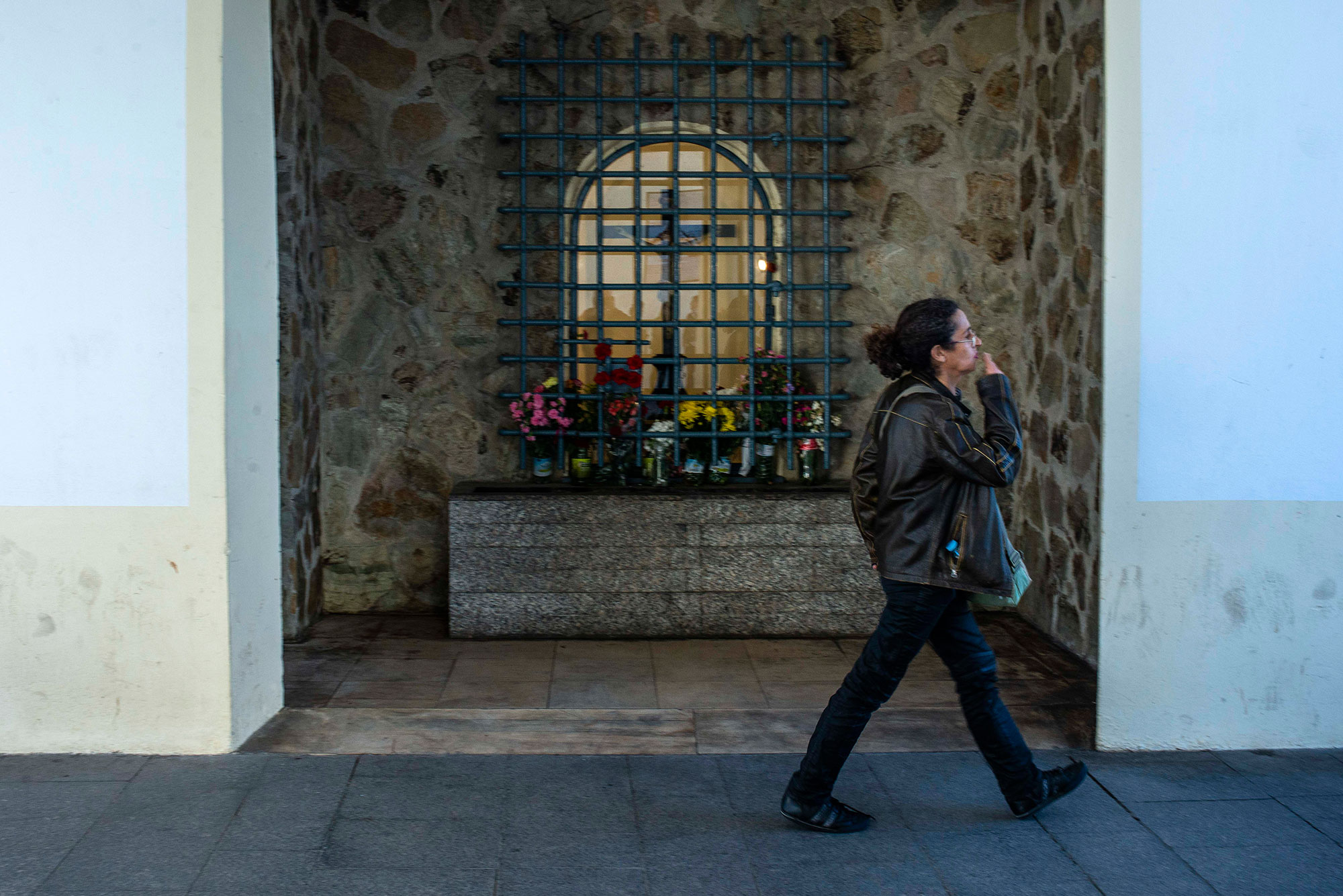 Una mujer se persigna ante el Cristo Una mujer se persigna ante el Cristo