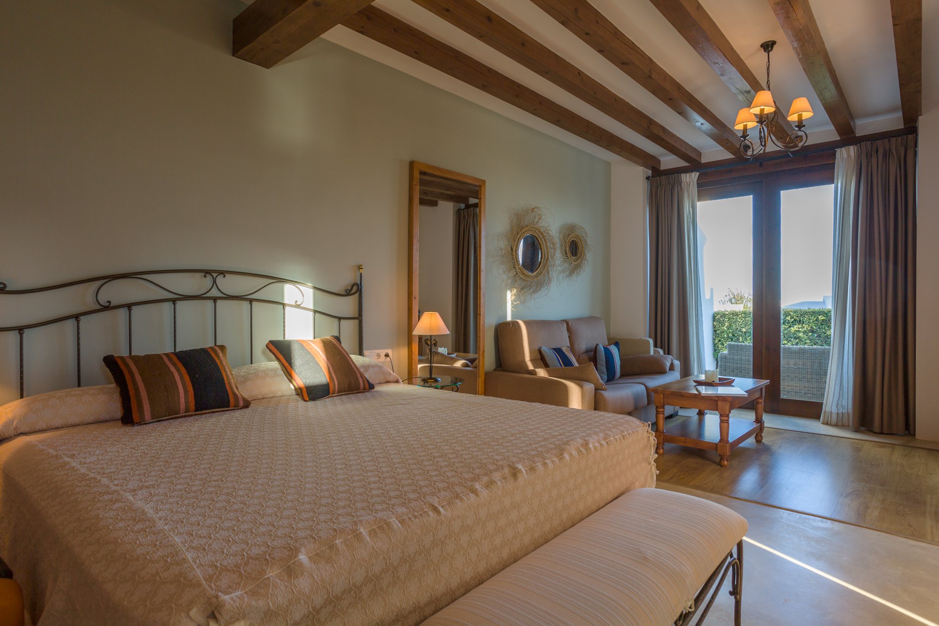 La madera, con vigas de sabina vista, el hierro forjado y el esparto en los detalles de decoración de las habitaciones. La madera, con vigas de sabina vista, el hierro forjado y el esparto en los detalles de decoración de las habitaciones.