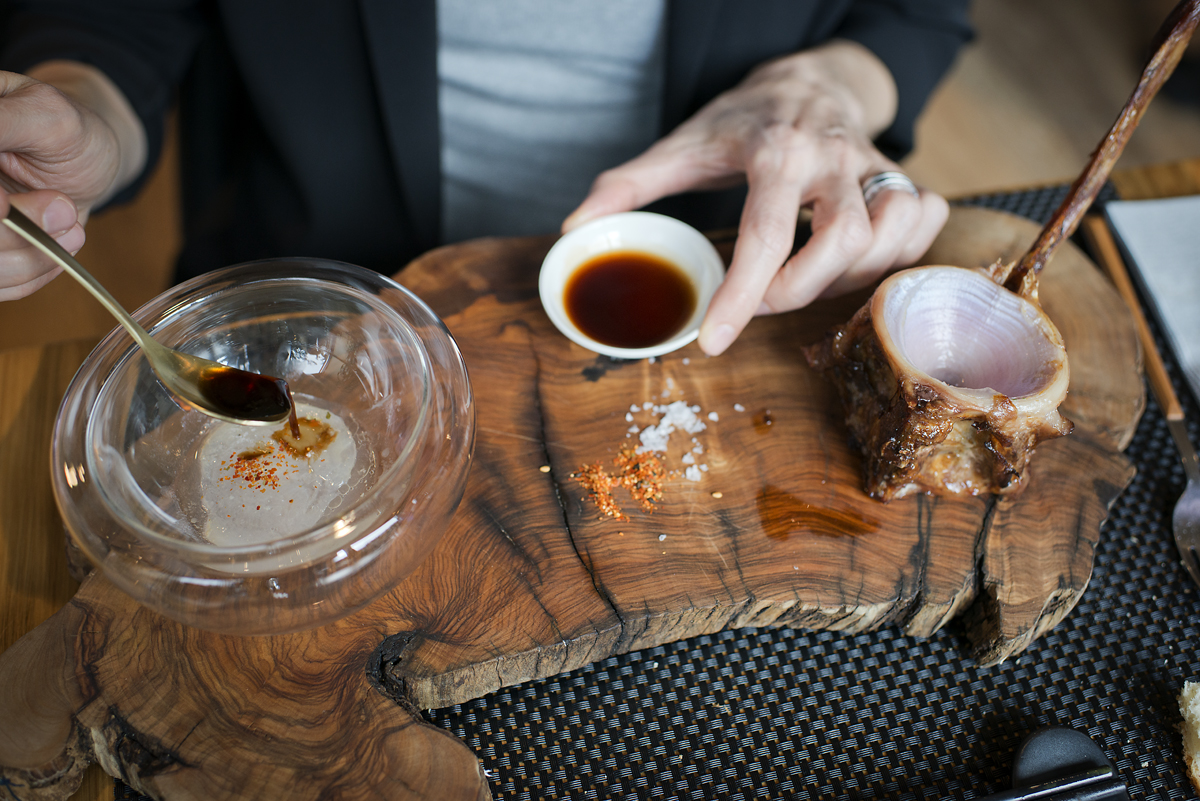 Un comensal mezcla en la mesa el tuétano con la salsa secreta de jengibre. Un comensal mezcla en la mesa el tuétano con la salsa secreta de jengibre.