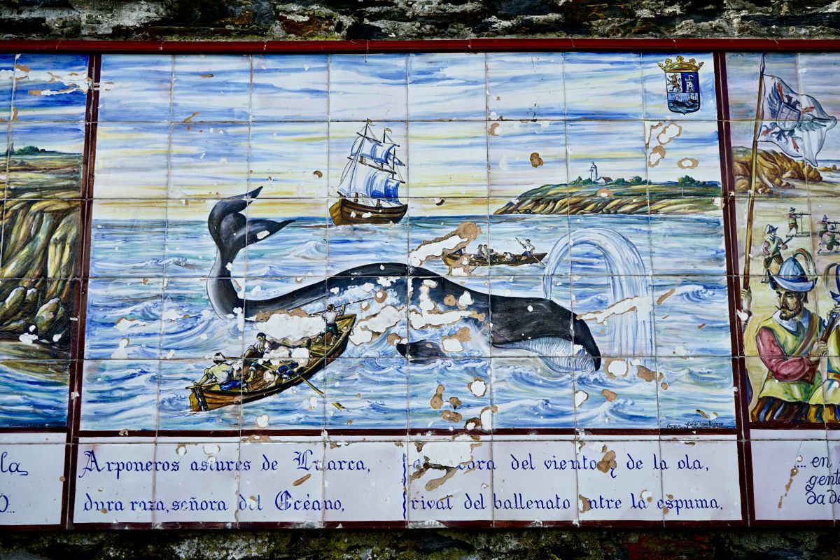 Vista del panel de cerámica de la Casa de los Mareantes en el que figura la caza de ballenas en Luarca, Asturias. Vista del panel de cerámica de la Casa de los Mareantes en el que figura la caza de ballenas en Luarca, Asturias.