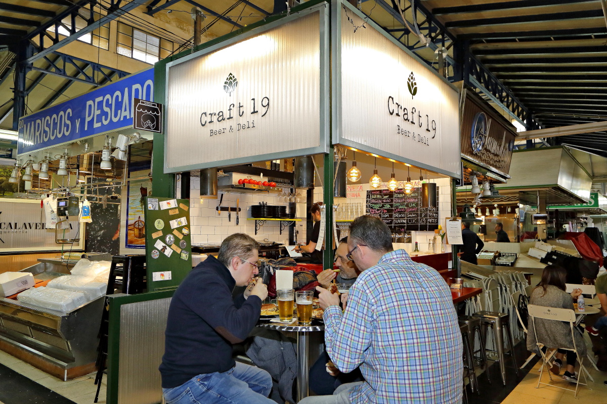 Unos clientes se comen un sándwich en las mesas de 'Craft 19' en el Mercado de Vallehermoso. Unos clientes se comen un sándwich en las mesas de 'Craft 19' en el Mercado de Vallehermoso.