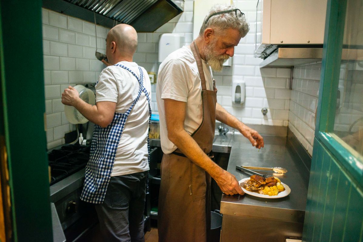 Fernando Lasala y Scott Preston de 'Los Chuchis Bar', en Lavapiés (Madrid) trabajando en su pequeña cocina. Fernando Lasala y Scott Preston de 'Los Chuchis Bar', en Lavapiés (Madrid) trabajando en su pequeña cocina.