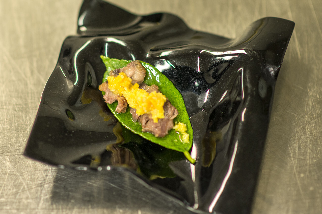 Carrillera de cordero sobre hoja de limonero y mole de naranja en salmuera, piñones y aove. Carrillera de cordero sobre hoja de limonero y mole de naranja en salmuera, piñones y aove.