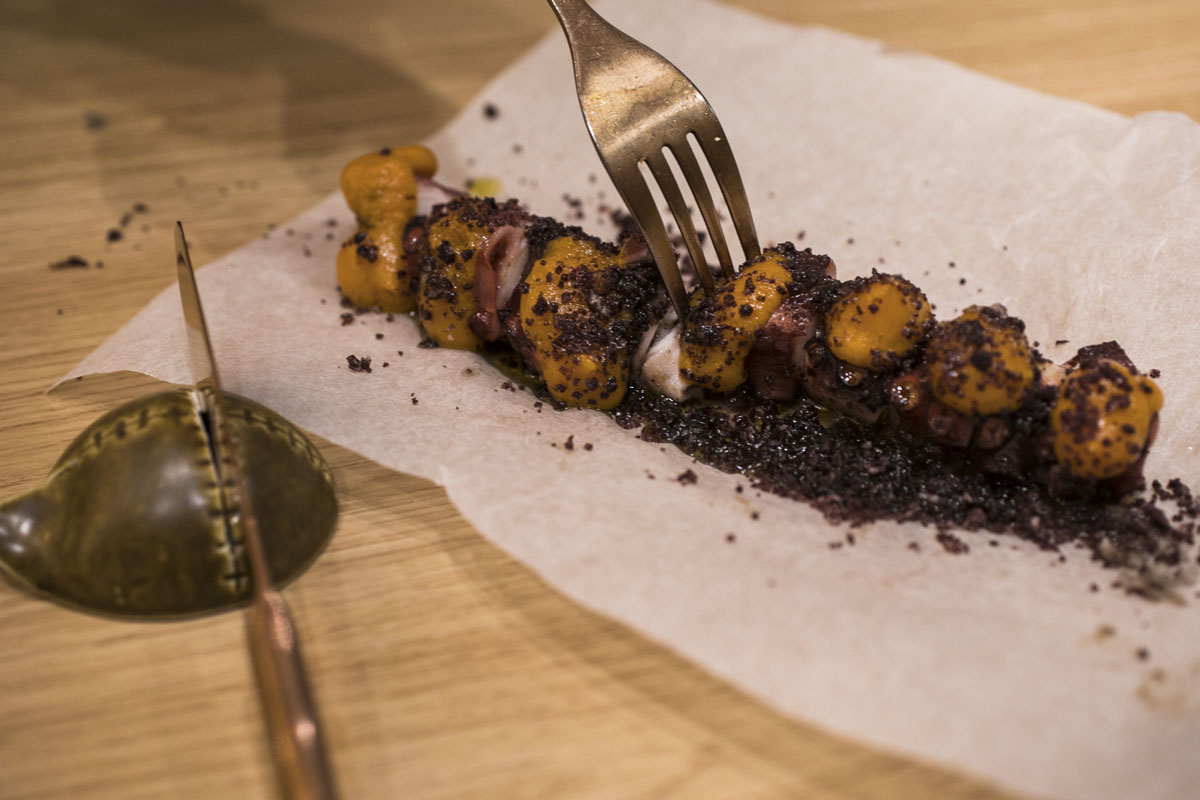 Pulpo a la brasa con emulsión de bonito ahumado y tierra de aceitunas negras. Pulpo a la brasa con emulsión de bonito ahumado y tierra de aceitunas negras.