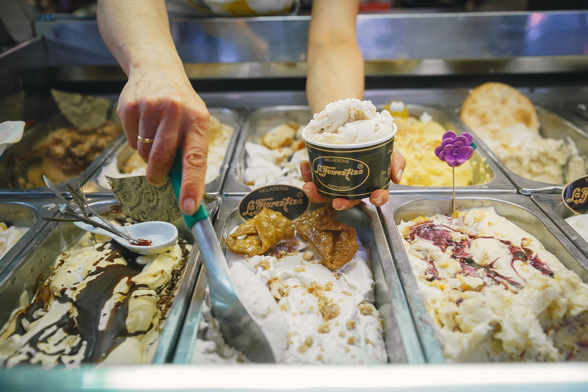 Heladero sirve una tarrina de helado Heladero sirve una tarrina de helado