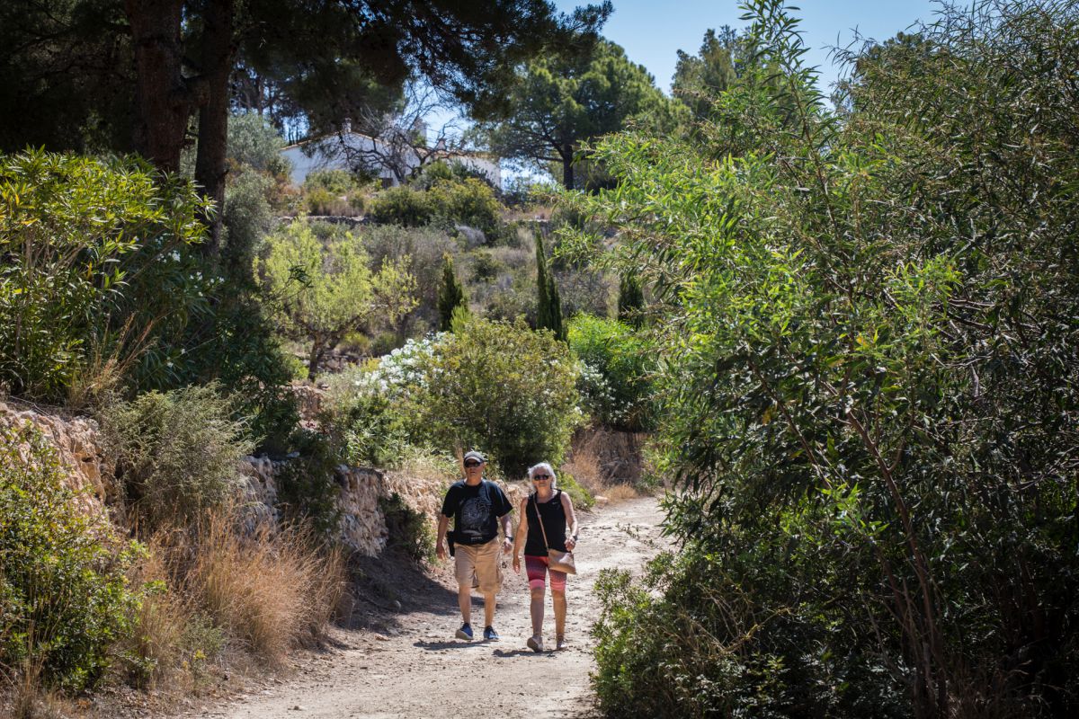 Una pareja de turistas camina por el paseo ecológico de Calpe, en Alicante. Una pareja de turistas camina por el paseo ecológico de Calpe, en Alicante.