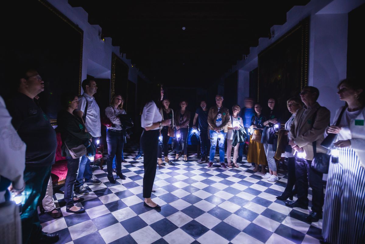 La guía de Engranajes Culturales recibe a los visitantes a la entrada del Hospital de la Caridad durante la visita nocturna, en Sevilla. La guía de Engranajes Culturales recibe a los visitantes a la entrada del Hospital de la Caridad durante la visita nocturna, en Sevilla.
