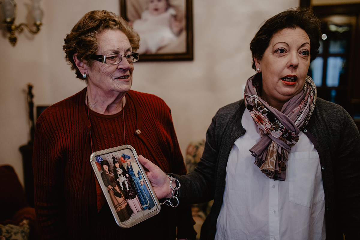 María y Gloria, en el salón de esta última, muestran una foto con las cuatro generaciones de viudas. María y Gloria, en el salón de esta última, muestran una foto con las cuatro generaciones de viudas.