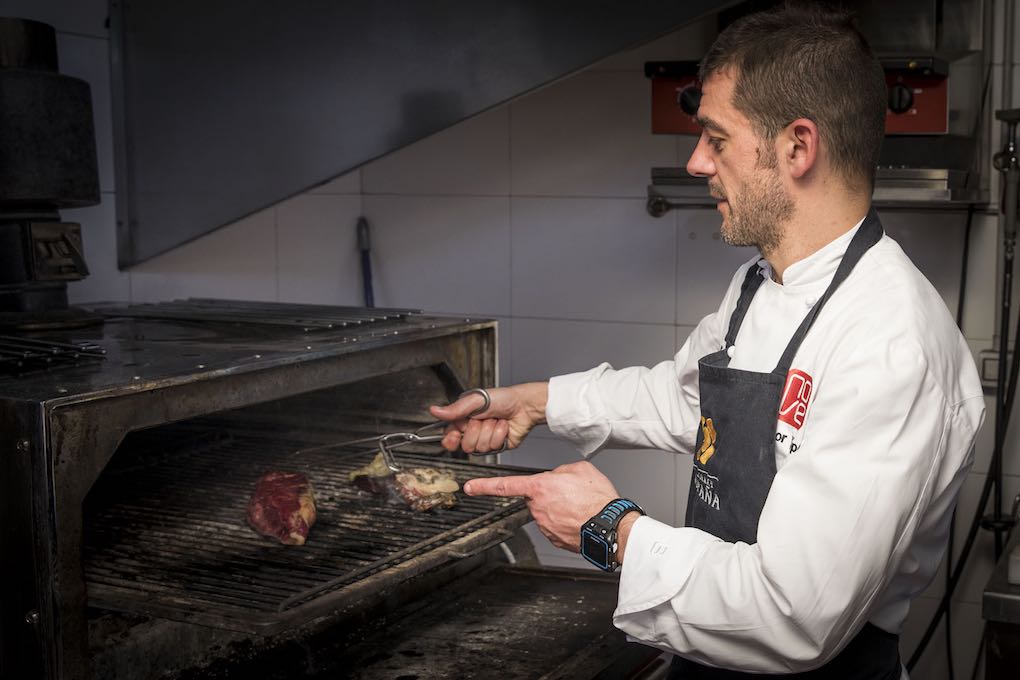 Héctor López cocinando carne de buey a la brasa Héctor López cocinando carne de buey a la brasa