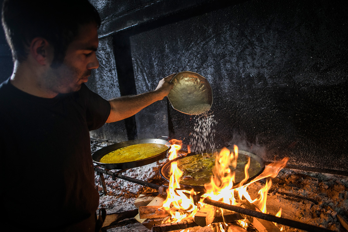 Marcos, a los mandos de las paellas, esparce el arroz que no se tocará hasta pasados 18 minutos. Marcos, a los mandos de las paellas, esparce el arroz que no se tocará hasta pasados 18 minutos.