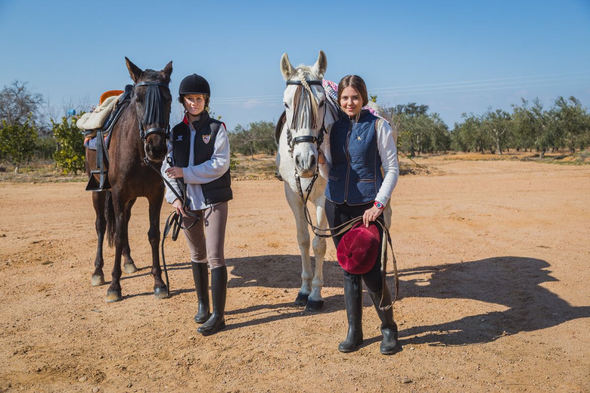 Las chicas desmontan de sus caballos (un pura raza español y un anglohispano) durante la vista a la yeguada. Las chicas desmontan de sus caballos (un pura raza español y un anglohispano) durante la vista a la yeguada.