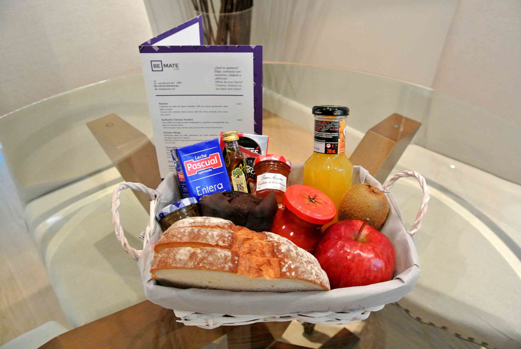 Cesta para desayunar compuesta por pan, leche, fruta, zumos y mermeladas Cesta para desayunar compuesta por pan, leche, fruta, zumos y mermeladas