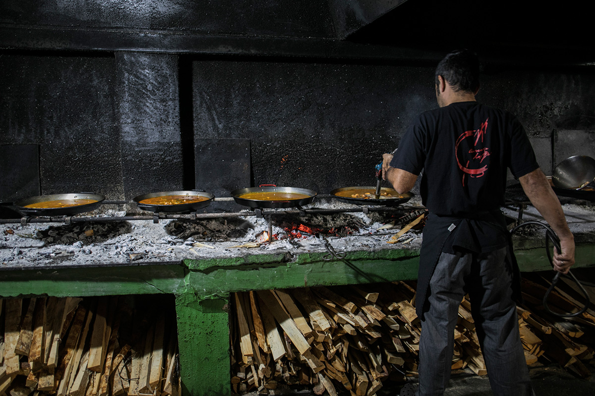 Marcos atento a varias paellas a la vez, cada una en un estadio diferente. Marcos atento a varias paellas a la vez, cada una en un estadio diferente.