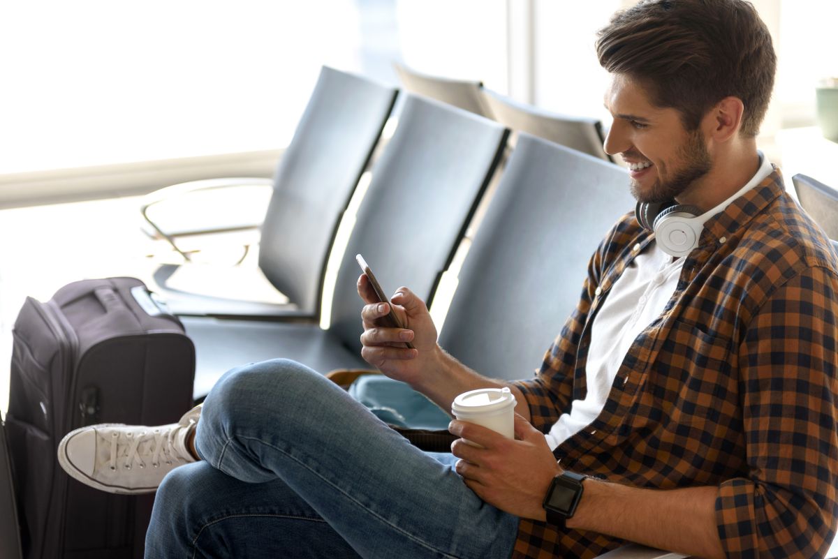 Un chico joven esperando el avión junto a su maleta. Un chico joven esperando el avión junto a su maleta.
