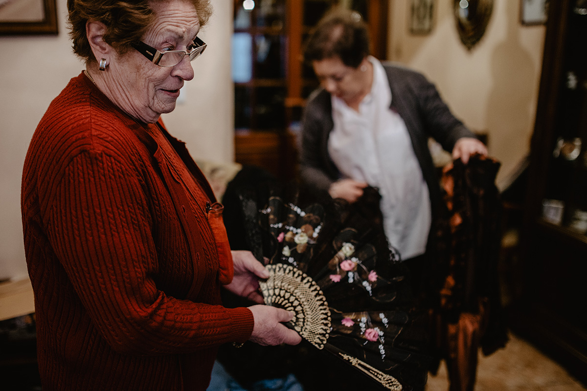 Gloria enseña un abanico de viuda mientras María busca entre los trajes de época que tienen. Gloria enseña un abanico de viuda mientras María busca entre los trajes de época que tienen.