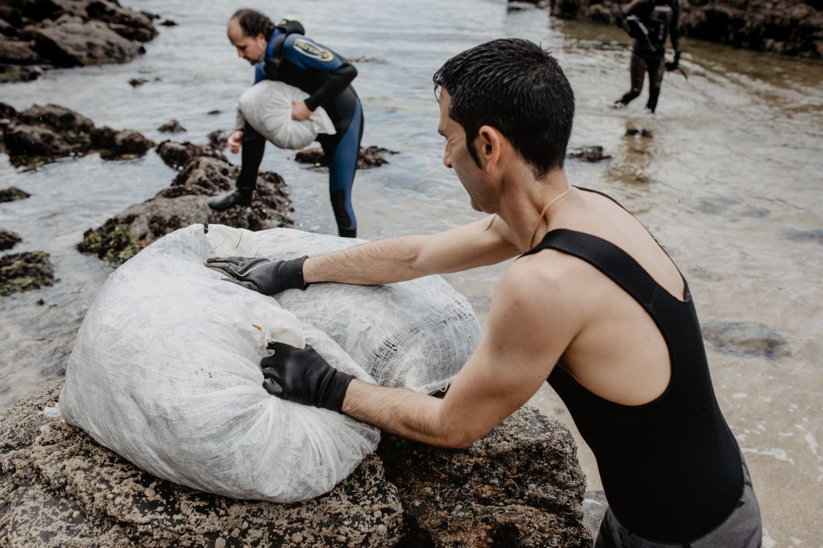 Sergio y Oscar, de Mar de Ardora, peleando con los pesados sacos de algas en las costas de Galicia. Sergio y Oscar, de Mar de Ardora, peleando con los pesados sacos de algas en las costas de Galicia.