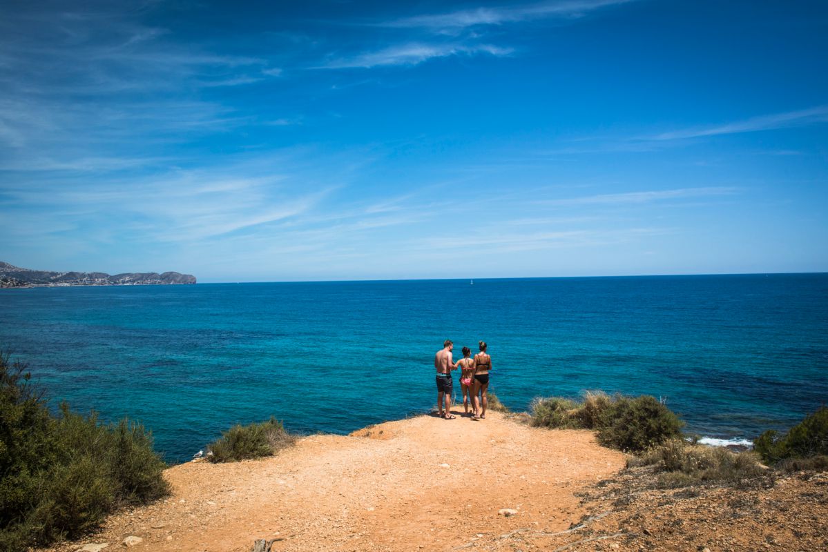 Unos bañistas miran hacia el mar en la cala del Peñón de Ifach, en Calpe, Alicante. Unos bañistas miran hacia el mar en la cala del Peñón de Ifach, en Calpe, Alicante.