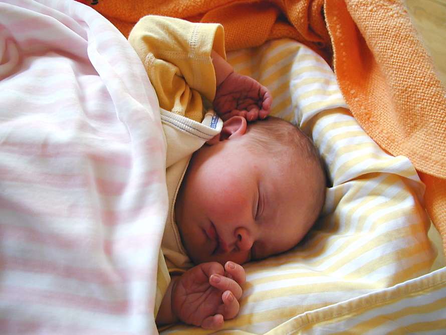 Babyn sover i sängen.