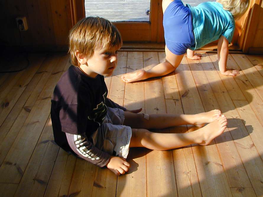 Pojken sitter på golvet och väntar.
