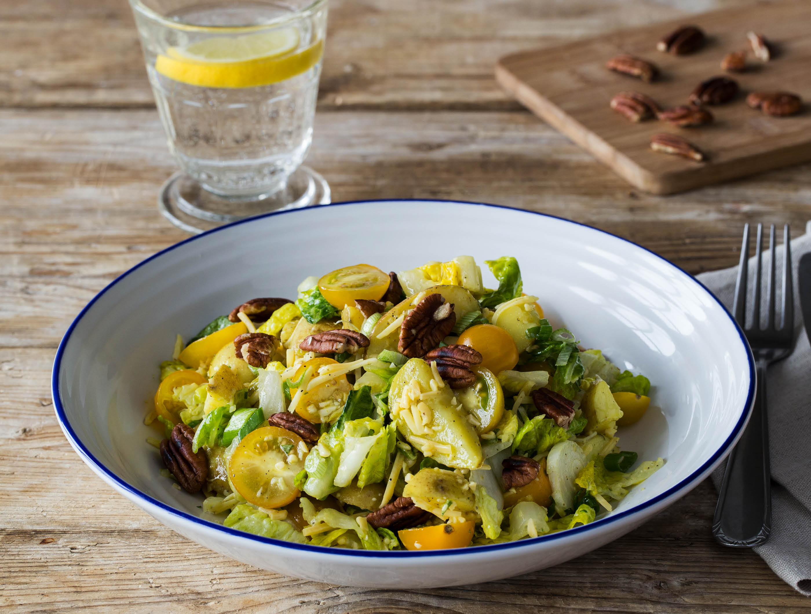 Zomerse krieltjessalade met sinaasappel-oreganodressing en oude komijnekaas Een frisse zomersalade met zoete gele tomaten