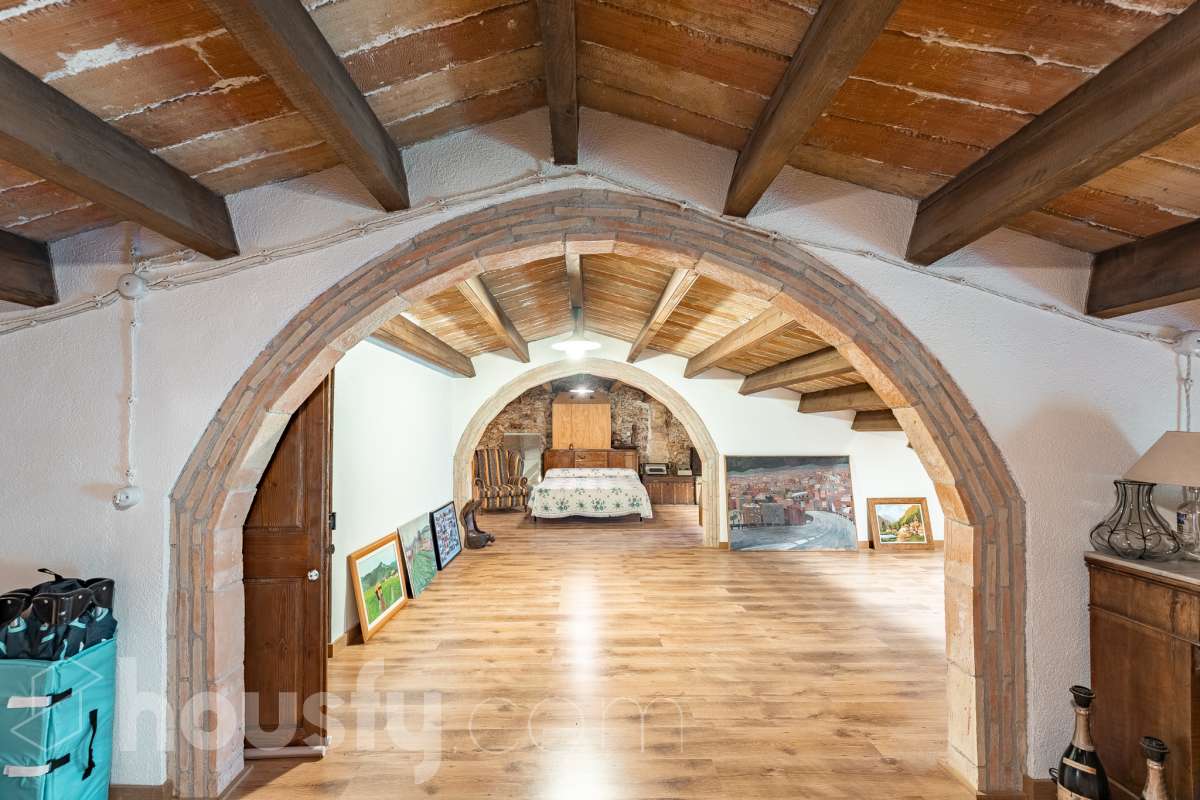 Housfy vende masía histórica de finales del S.XIX – El corazón del Penedès Descubra esta excepcional masía de piedra, un oasis de tranquilidad y autenticidad restaurado minuciosamente en 2010. Con una superficie construida de 351 m² sobre una extensa parcela de 8.502 m², esta propiedad combina a la perfección la tradición arquitectónica catalana con el máximo confort moderno. Lo que hace única a esta propiedad: Arquitectura y carácter: Restauración fiel que preserva elementos originales: vigas de madera de melis, techos de "volta catalana", suelos de mosaico antiguo y carpintería tradicional. Un viaje en el tiempo sin renunciar a las comodidades actuales. Entorno privilegiado: Ubicada en el corazón vinícola del Penedès, a tan solo 50 km de Barcelona y el aeropuerto, y a 20 km de Sitges. Disfrute de un entorno natural rodeado de viñedos, perfecto para actividades al aire libre como senderismo o rutas ecuestres. Zona exterior diseñada para disfrutar: Un espacio exterior con porches de columnas milenarias, piscina y una completa zona de barbacoa/horno de leña tradicional. Incluye una zona de sombra natural bajo moreras centenarias, huerto privado, frutales y un espacio polivalente de 3.700 m² apto para instalaciones hípicas. Sostenibilidad y equipamiento: La casa cuenta con sistema de calefacción geotérmica de alta eficiencia, pozos propios (caudal garantizado de 9.000 l/h), depuradora ecológica y conexión a fibra óptica, garantizando un funcionamiento autónomo y eficiente. Distribución y detalles: Amplios espacios interiores, incluyendo una biblioteca, cocina rústica de 28 m² con chimenea, gran salón de reuniones con capacidad para 24 comensales y bodega. La planta superior conserva el encanto original con acceso a un desván polivalente de 90 m². Esta propiedad es ideal para quienes buscan una residencia singular, un refugio de fin de semana o una oportunidad de inversión en una de las zonas más demandadas y con mayor encanto de Cataluña. Quiere visitarla? Contacte con Housfyy agende su visita sin compromiso. Más información en: housfy.com-26